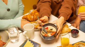 Una colazione con croissant, una ciotola di zuppa e un bicchiere di succo d'arancia.