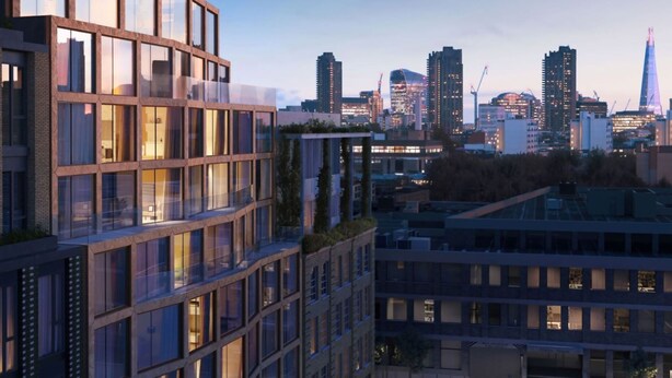 A modern high-rise building with large windows and a curved facade, set against a city skyline with various buildings and a prominent tower. - Maldron Hotel Shoreditch London (London)
