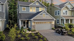 Un quartier résidentiel comprenant plusieurs maisons, une allée et un véhicule de type voiturette de golf.
