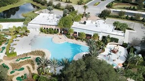 An aerial view of a resort with a large swimming pool, landscaped areas, and a building with a flat roof. - 3 BR, 2.5 BA Villa | Sleeps 8! (Davenport)