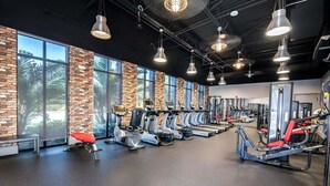 A gym with exercise equipment, large windows, and a brick wall. - 3 BR, 2.5 BA Villa | Sleeps 8! (Davenport)