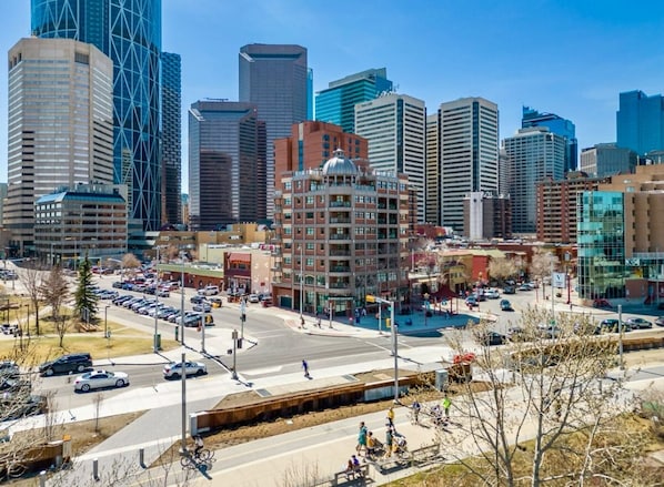 A cityscape with modern buildings, a central plaza, and a parking area.