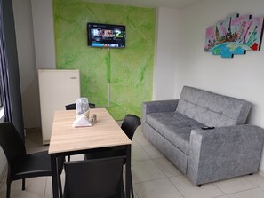 Relax in this well-appointed room featuring a flat-screen TV, comfortable sofa, and kitchenette.