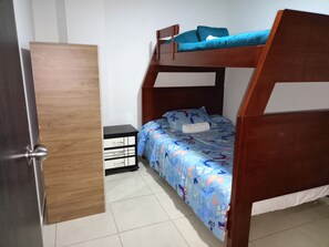 Cozy bedroom with a bunk bed, nightstand, and comfortable bedding.