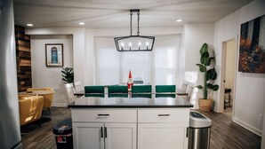 A modern kitchen with white cabinets, a central island, and a hanging light fixture. - Amazing 6 bdrm Downtown KC/Near Plaza/UMKC (Kansas City)