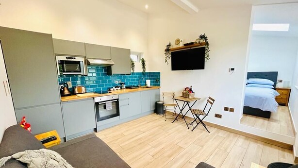 Un appartement moderne comprenant une cuisine, un coin repas et une chambre.