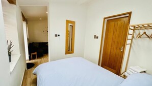 Une chambre à coucher avec un lit, une porte en bois et une petite table.