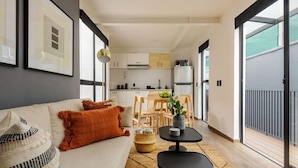 Un appartement moderne comprenant un salon, une cuisine et un balcon.