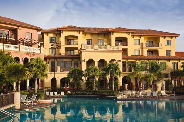 Un hôtel doté d’une piscine et agrémenté de plusieurs balcons et de palmiers.