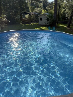 A clear swimming pool surrounded by trees and a small building. - Robin's Nest Savannah (Savannah)