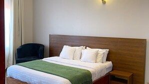 Un dormitorio ordenado con una cama de madera, una mesita de noche y una silla.
