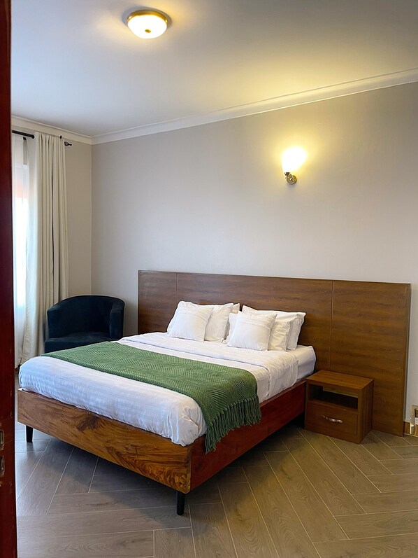 Un dormitorio ordenado con una cama de madera, una mesita de noche y una silla.