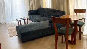 Una sala de estar moderna con un sofá modular, una mesa de comedor y sillas.