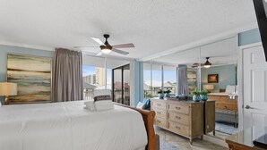 Un dormitorio con cama, cómoda, espejo y ventilador de techo.