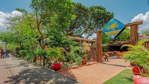 Entrada a un restaurante con un letrero que dice "Souza Bar Restaurante" y una estructura de madera.
