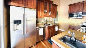 A kitchen with wooden cabinets, stainless steel appliances, and a granite countertop. - Lake Winnisquam water front home  (Belmont)
