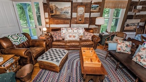 A cozy living room with a brown leather sofa, a wooden coffee table, and a patterned rug. - Historic Parker’s Landing
(Springfield)