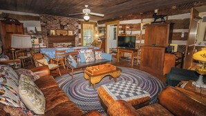 A rustic living room with a fireplace, wooden furniture, and a television. - Historic Parker’s Landing
(Springfield)