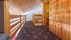 A wooden interior with a sloped ceiling, a wooden bench, and a patterned carpet. - 100m from ski slopes, 3rd floor, view mountain, balcony, tv, ski locker, 45m², Montchavin La Plagne (Bellentre)