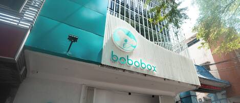 A building with a 'bobobox' sign, a white and teal color scheme, and a sign that says 'Sleep Better Worry Less'.