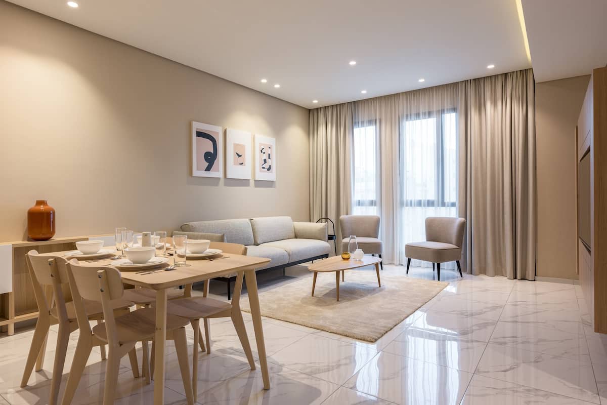 A modern living room with a dining area, a sofa, a coffee table, and a TV.