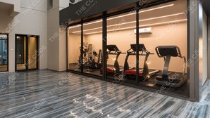 Une salle de sport moderne, dotée d’équipements d’exercice, de murs en verre et d’un sol poli.
