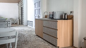 A compact kitchenette with a microwave, toaster, and sink. - Bobopod Kota Lama Semarang (Semarang)
