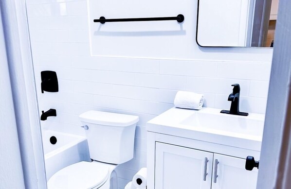 A modern bathroom with a toilet, sink, and bathtub. - Sapphire by the Sea Unit 8 - King Pool View Suite, kitchen, pool view, Sleeps 2 (Fort Lauderdale)