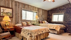 A rustic bedroom with two beds, wooden walls, and a large window. - Edge Water Lodge (EV), Waters Edge Lodge (Fremont County)