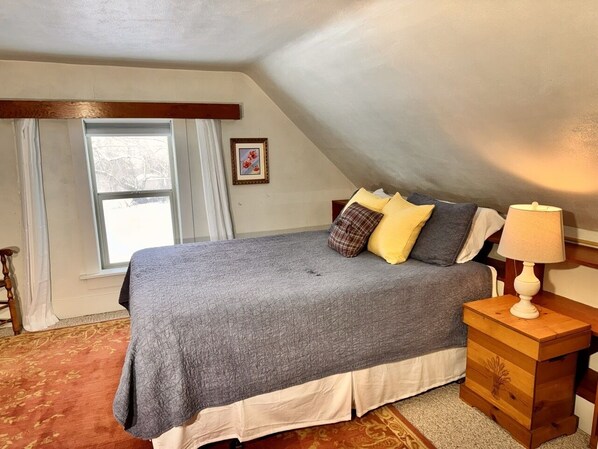 A bedroom with a bed, a nightstand, a lamp, a window, and a picture on the wall. - Edge Water Lodge (EV), Waters Edge Lodge (Fremont County)