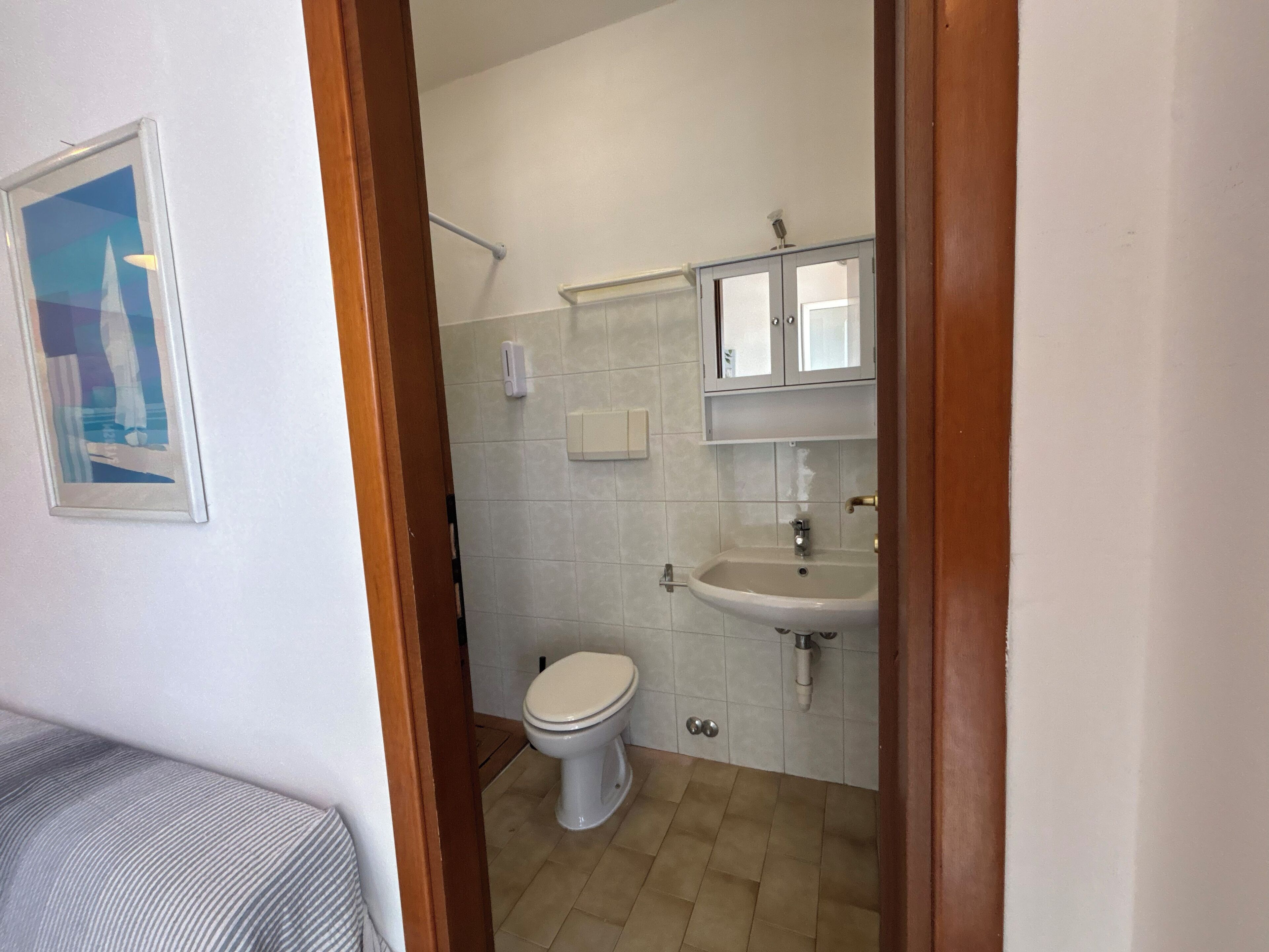 Un baño con inodoro, lavabo y espejo.