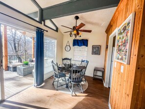 A dining area with a table, chairs, and a ceiling fan.