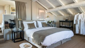 Une chambre à coucher avec un grand lit, une table de chevet, un miroir et une armoire.