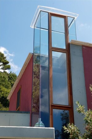 A modern building with a large glass window and a red facade.