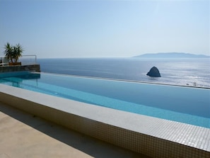 Ein Infinity-Pool mit Blick auf das Meer und eine Felsformation.