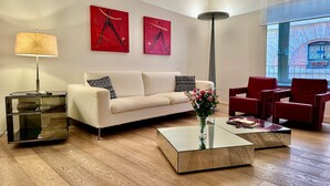 A modern living room with a sofa, two armchairs, a coffee table, a floor lamp, and artwork on the walls. - In Rome at Spanish Steps Classy Apartment With Modern Design in an Historic Palazzo (Rome)