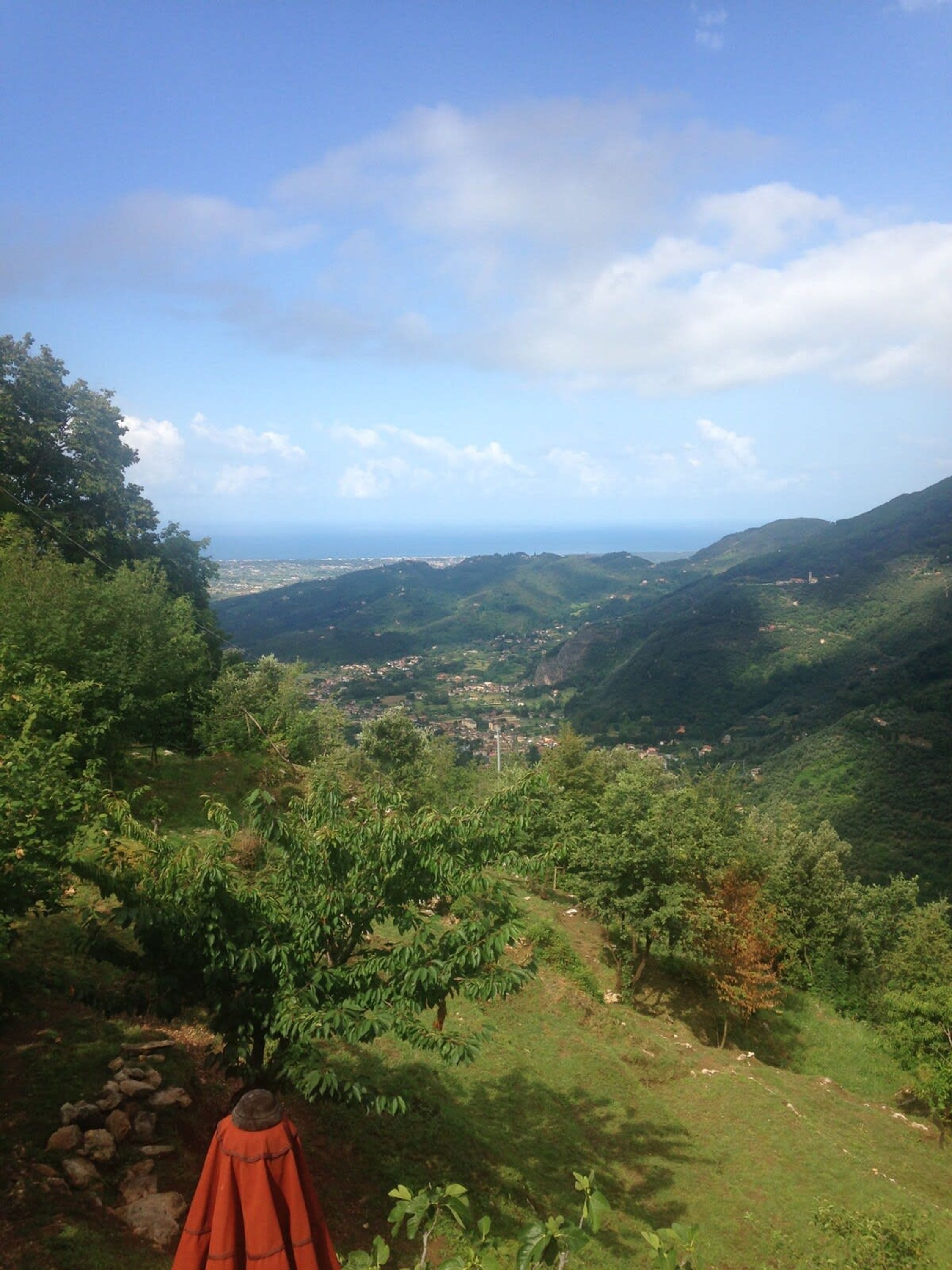 A mountainous landscape with a view of a valley and a distant town.