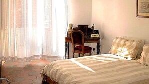 Ein Schlafzimmer mit Bett, Schreibtisch und Stuhl.