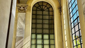 A grand arched doorway with a grid of glass panes, flanked by classical columns and a balustrade. - L Ortensia Bianca in Palazzo Ruspoli a Superb Retreat in the Most Elegant Palace in Rome (Rome)