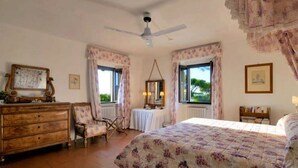 A bedroom with a bed, dresser, chair, and windows with curtains. - In the Maremma Classic Tuscany Villa With Pool Near the Sea (Castagneto Carducci)