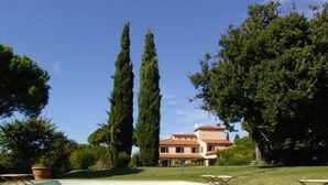 A villa with a swimming pool, surrounded by tall trees and a well-maintained lawn. - In the Maremma Classic Tuscany Villa With Pool Near the Sea (Castagneto Carducci)