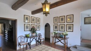 A room with a wooden ceiling, a chandelier, a dining table with chairs, and framed pictures on the walls. - In the Maremma Classic Tuscany Villa With Pool Near the Sea (Castagneto Carducci)
