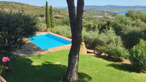 A swimming pool surrounded by lush greenery and a scenic view of hills and a body of water. - Porto Ercole Villa Della Fonte Large Pool Fabulous Sea Views (Monte Argentario)