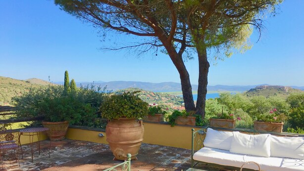 A terrace with a sofa, a glass table, and potted plants. - Porto Ercole Villa Della Fonte Large Pool Fabulous Sea Views (Monte Argentario)