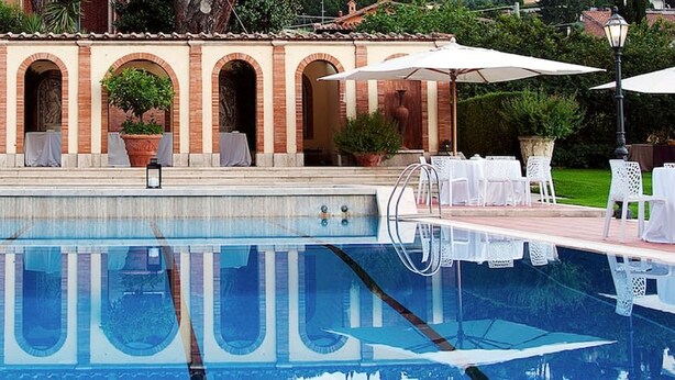 A swimming pool with a tiled deck, white chairs, and umbrellas. - Near Rome Villa Pool Tennis Courts Perfect Family Reunion or Off-site Meeting (Grottaferrata)