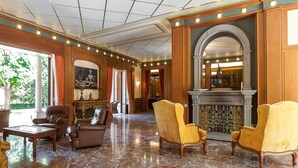 A spacious lobby with marble flooring, leather armchairs, and a fireplace. - Near Rome Villa Pool Tennis Courts Perfect Family Reunion or Off-site Meeting (Grottaferrata)