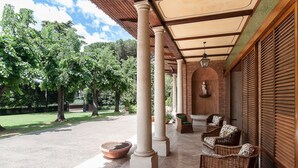 A covered outdoor seating area with wicker furniture and a statue. - Near Rome Villa Pool Tennis Courts Perfect Family Reunion or Off-site Meeting (Grottaferrata)