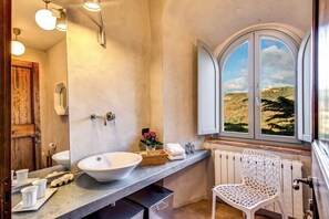 A bathroom with a large window, a white sink, and a chair. - Torre Fortunata Splendidly Restored Medieval Tower Near Todi in Umbria (Todi)