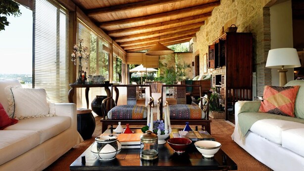 A cozy living room with a wooden ceiling, a sofa, a coffee table with decorative items, and a view of the outdoors. - Villa Vinarte Elegant Home 2 Pools Tennis spa Winery Exclusively for you (Castiglione in Teverina)