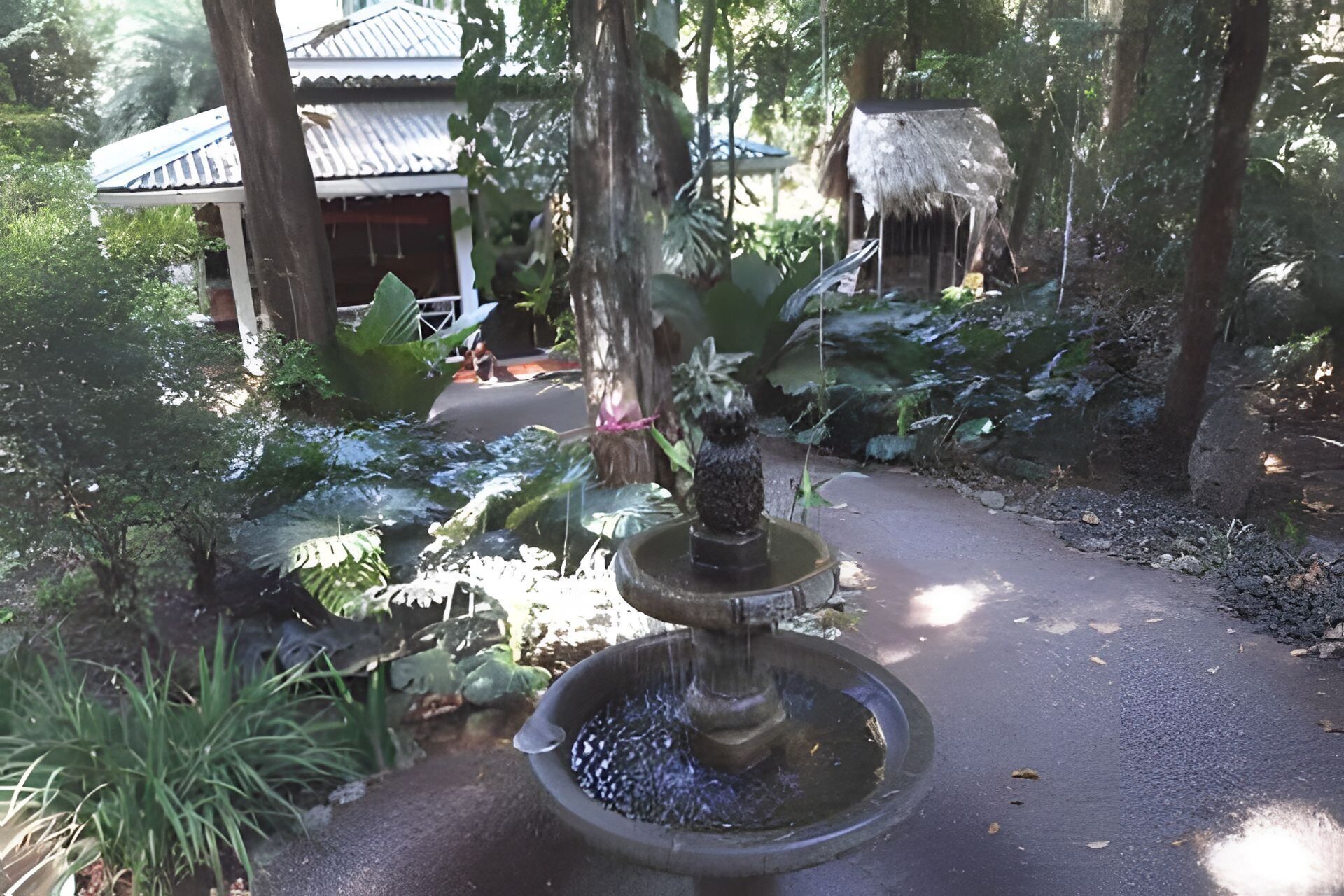 A stone fountain with water flowing in a garden setting.